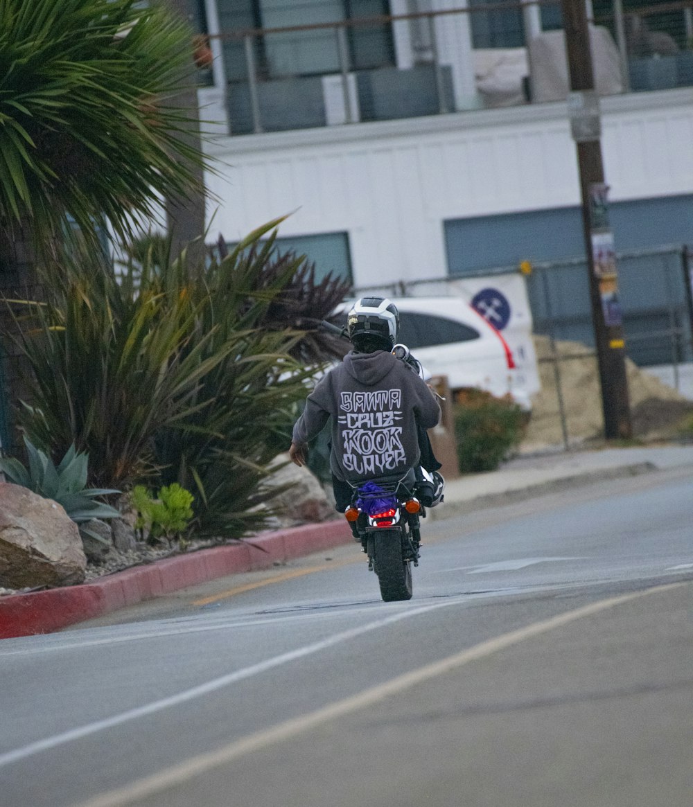 a man riding a motorcycle down a street