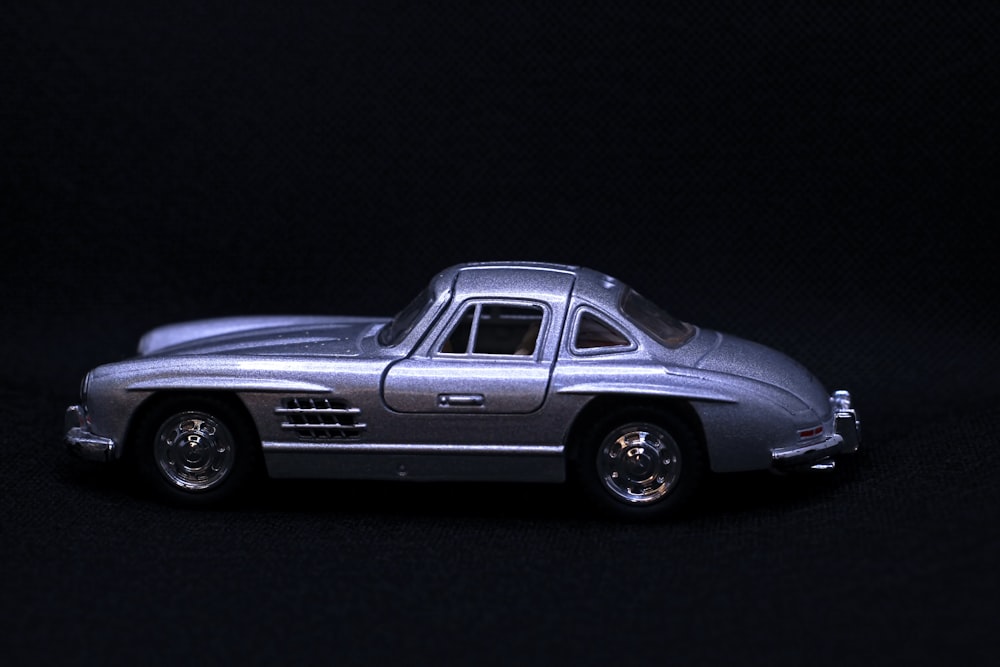 a silver toy car on a black background