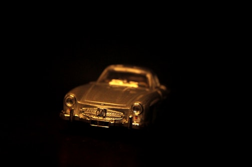 Close-up of a classic metal diecast model car on a wooden shelf capturing fine details.