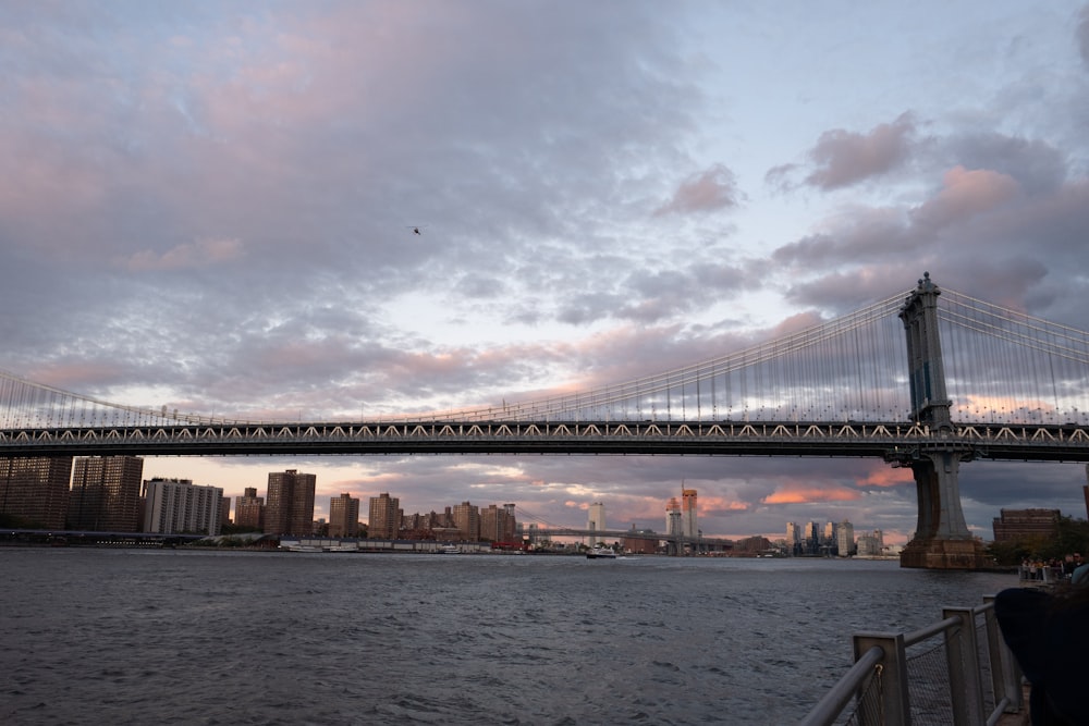 a bridge over a body of water with a city in the background