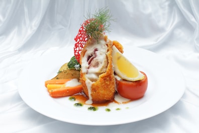 a white plate topped with meat and vegetables