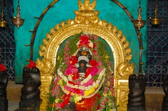 Front view of Maa Kamakhya temple adorned with marigold garlands during morning aarti.