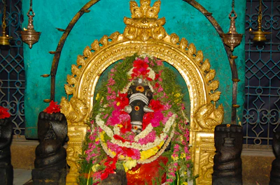 Close-up of the deity adorned with fresh jasmine and rose garlands.