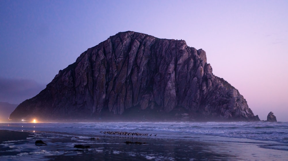 a large rock in the middle of the ocean