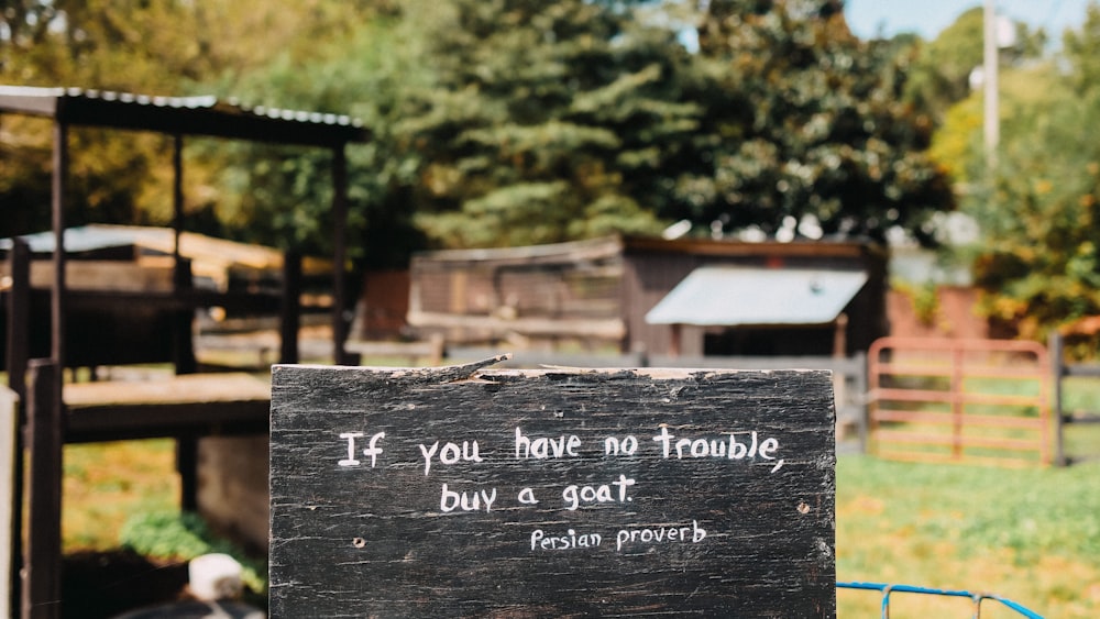 a wooden sign that says it you have no trouble buy a goat