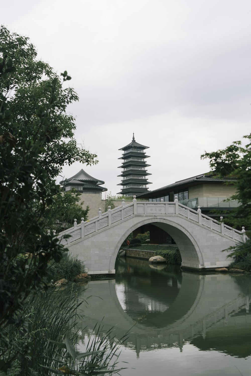 a bridge over a body of water with a pagoda in the background