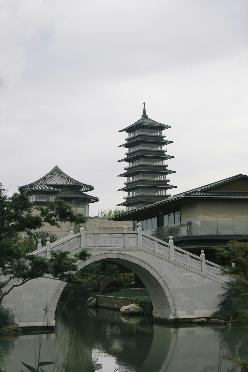 a bridge over a body of water with a building in the background