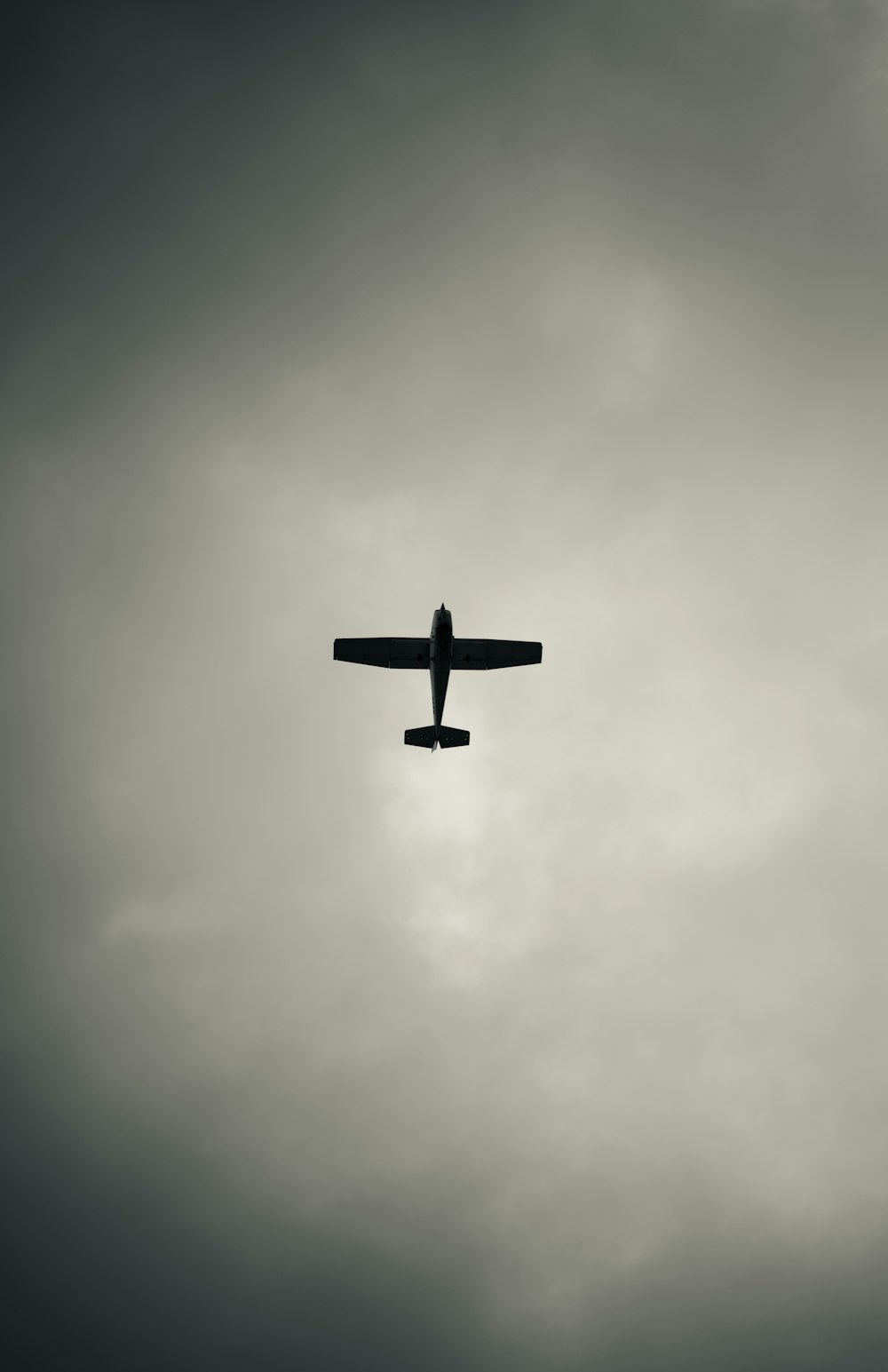 an airplane flying through a cloudy sky on a cloudy day