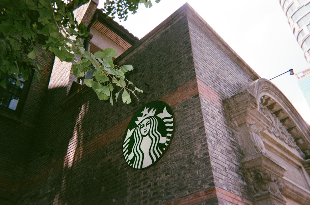 a starbucks sign on the side of a brick building