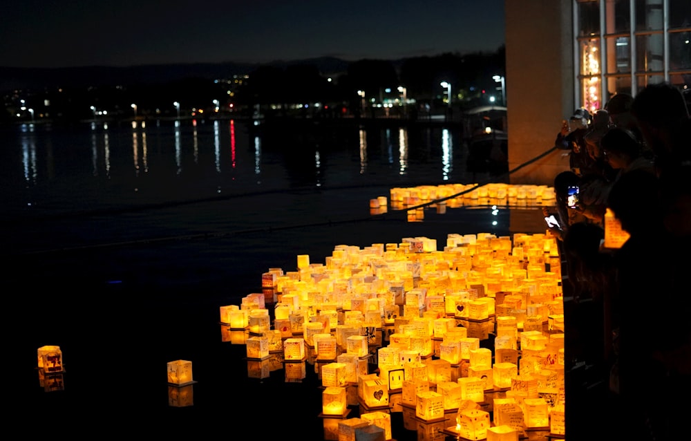 a group of people standing next to a bunch of lit candles