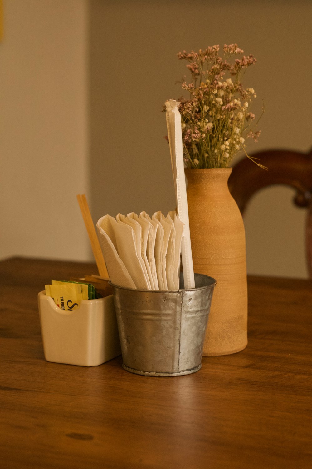 a wooden table topped with a metal container filled with books