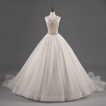A stunning bridal gown displayed on a mannequin with intricate lace and beadwork.