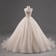 A luxurious, strapless ball gown with intricate lace detailing on the bodice, featuring a voluminous tulle skirt. The dress is displayed on a mannequin against a plain grey background.