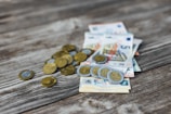 a pile of money sitting on top of a wooden table