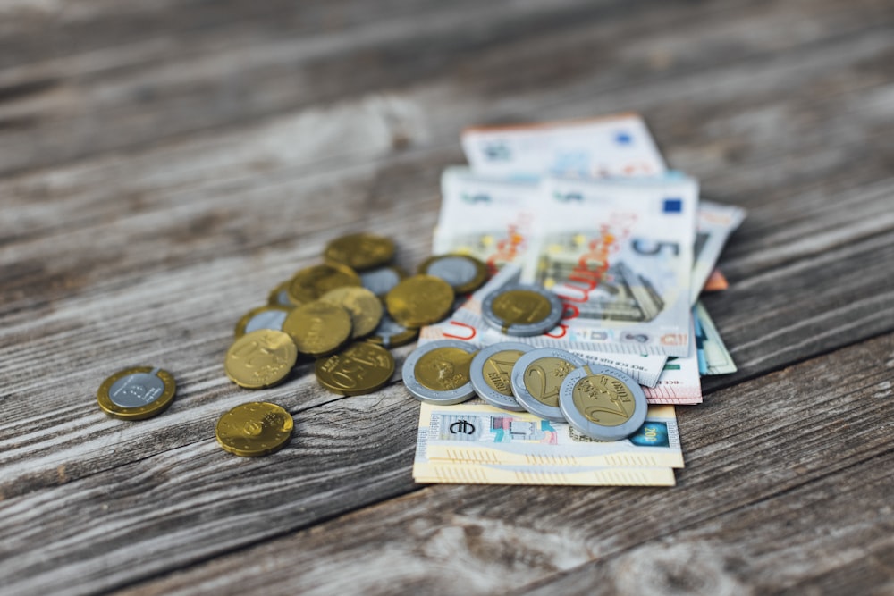 a pile of money sitting on top of a wooden table