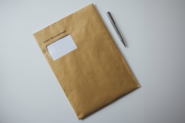a brown envelope with a pen on top of it