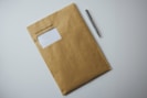 a brown envelope with a pen on top of it