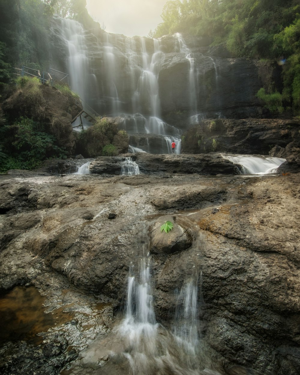 a man standing in front of a waterfall