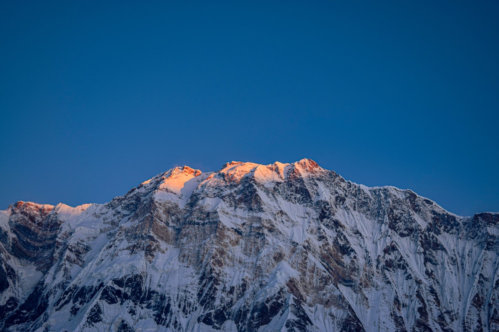 a snow covered mountain with a blue sky in the background