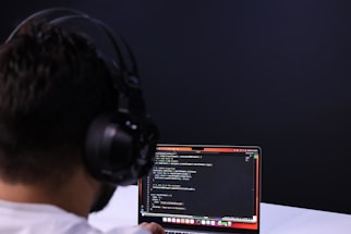 a man wearing headphones and using a laptop