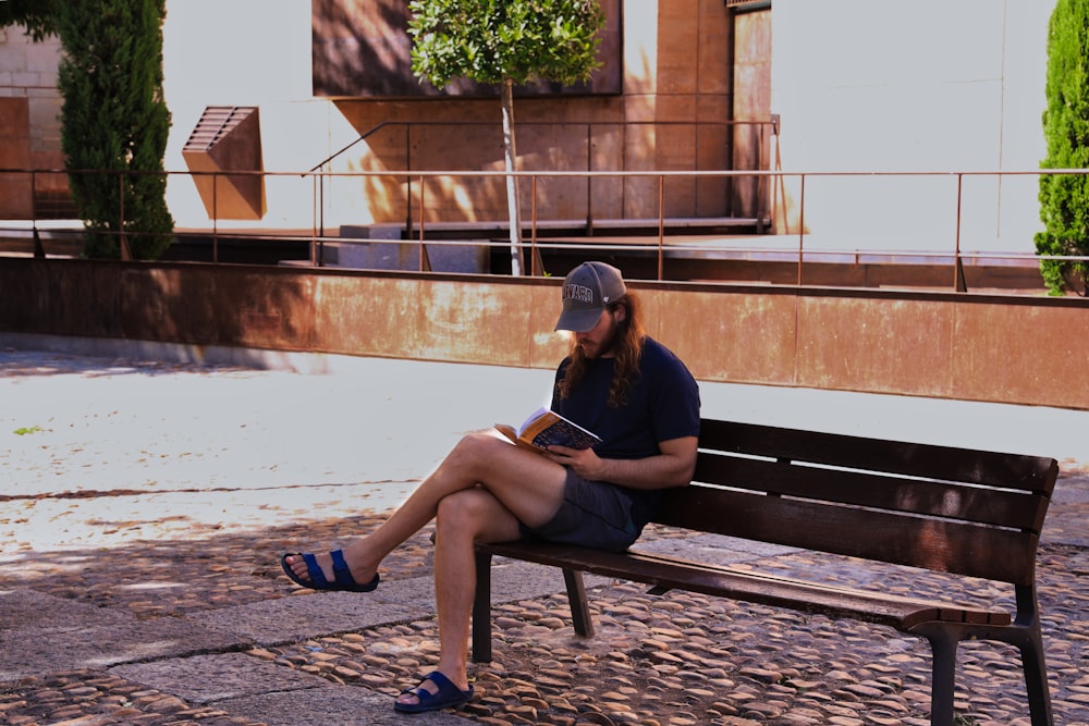 a woman sitting on a bench reading a book