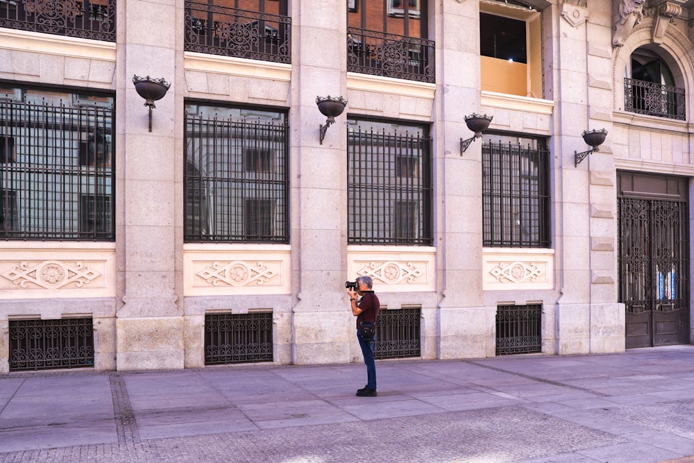 Un homme debout devant un grand immeuble