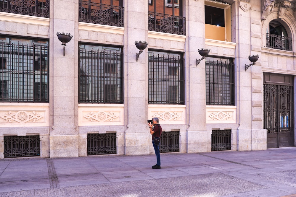 a man standing in front of a tall building