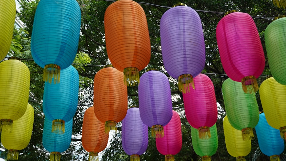 a bunch of colorful paper lanterns hanging from a line
