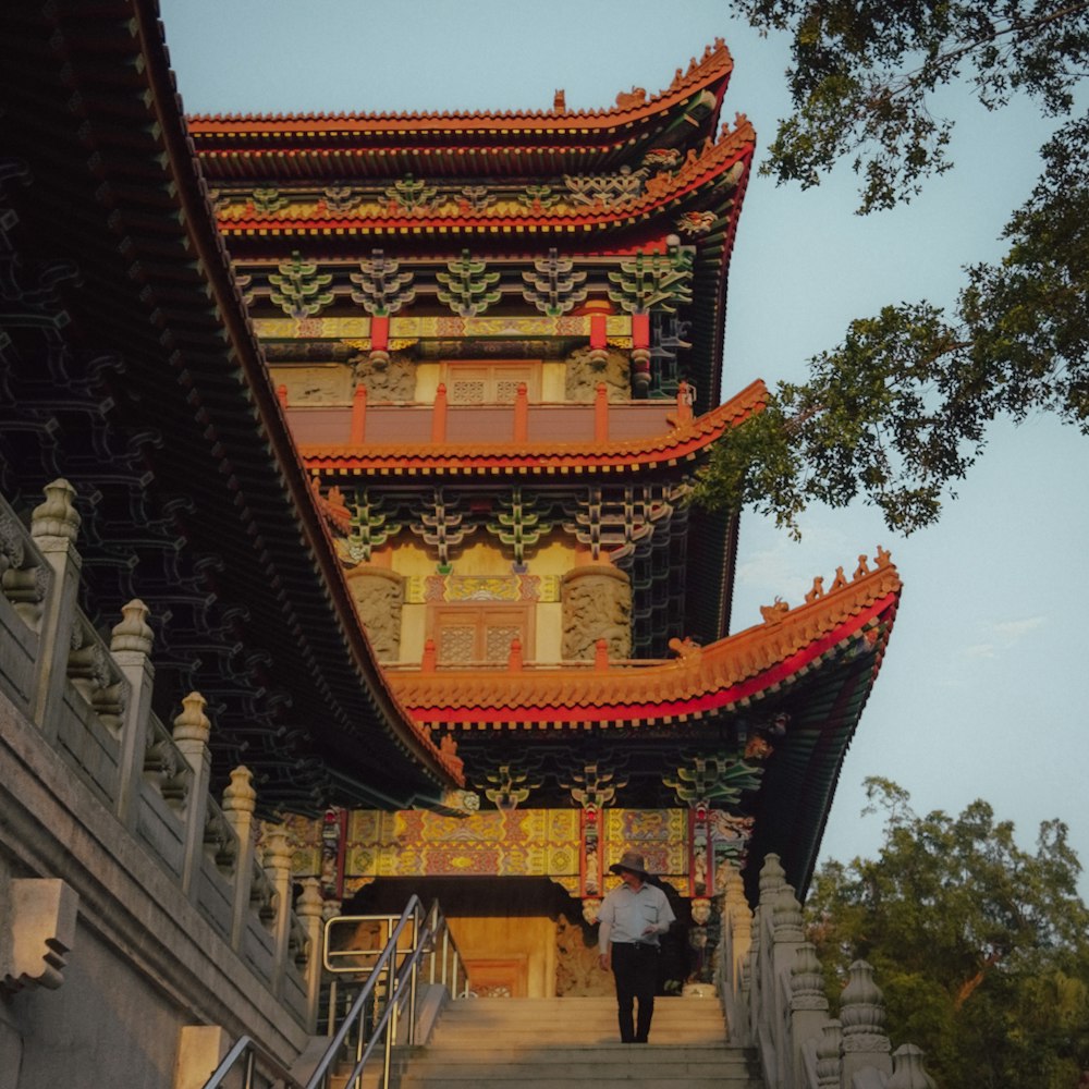 a man walking up a flight of stairs in front of a building