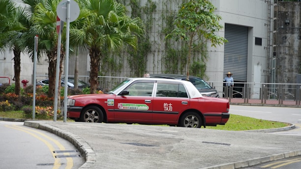 A sleek modern taxi car waiting at a busy Kuwait street corner.