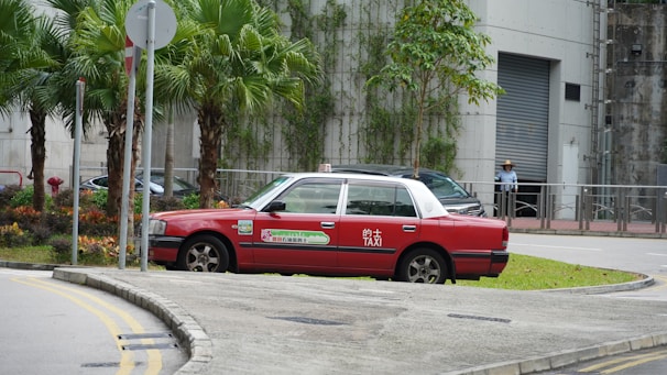 A friendly taxi driver helping a passenger with luggage near a taxi in Corralejo.