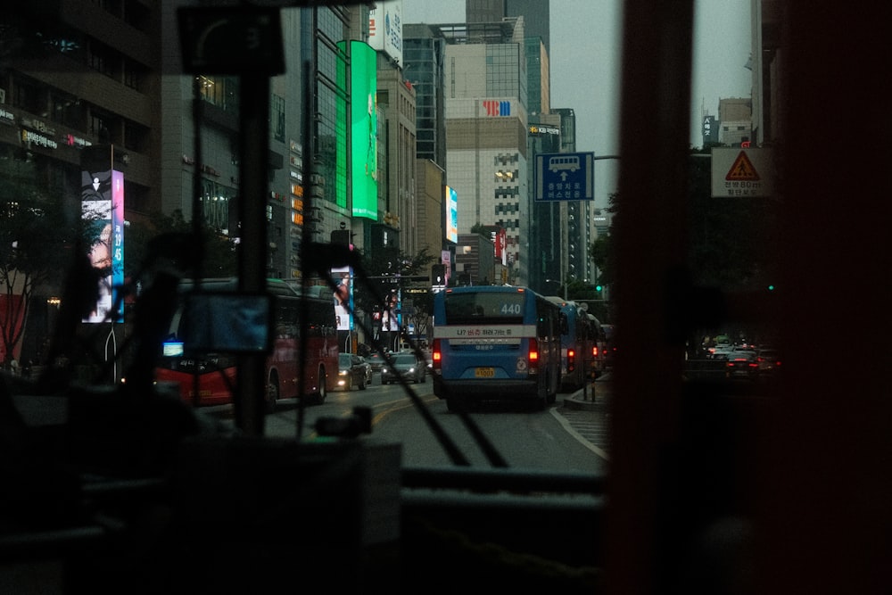 a bus driving down a street next to tall buildings