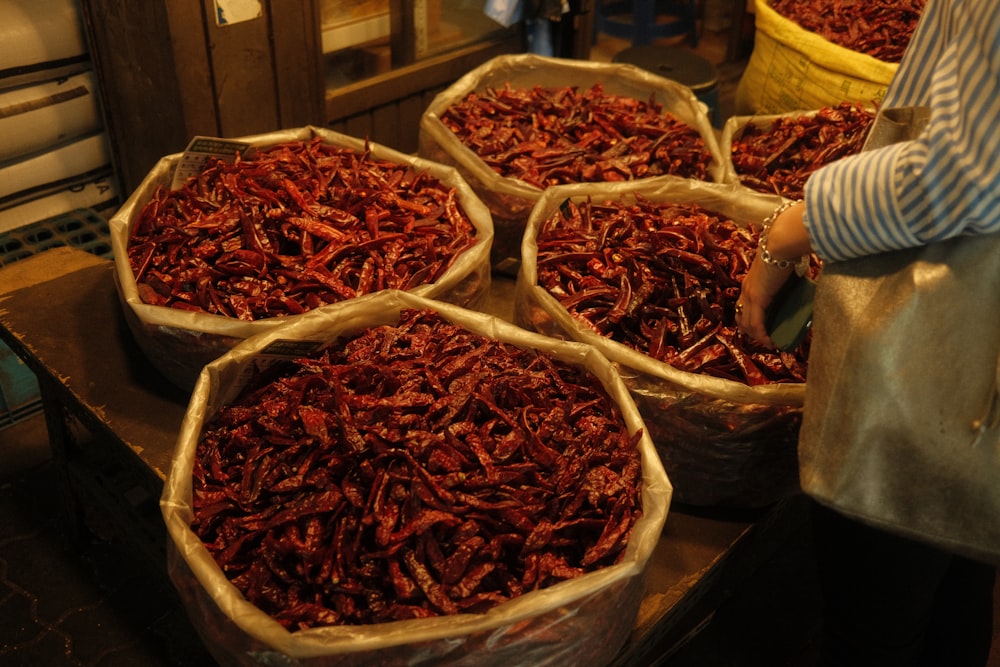 a woman holding a bag of dried red chili peppers