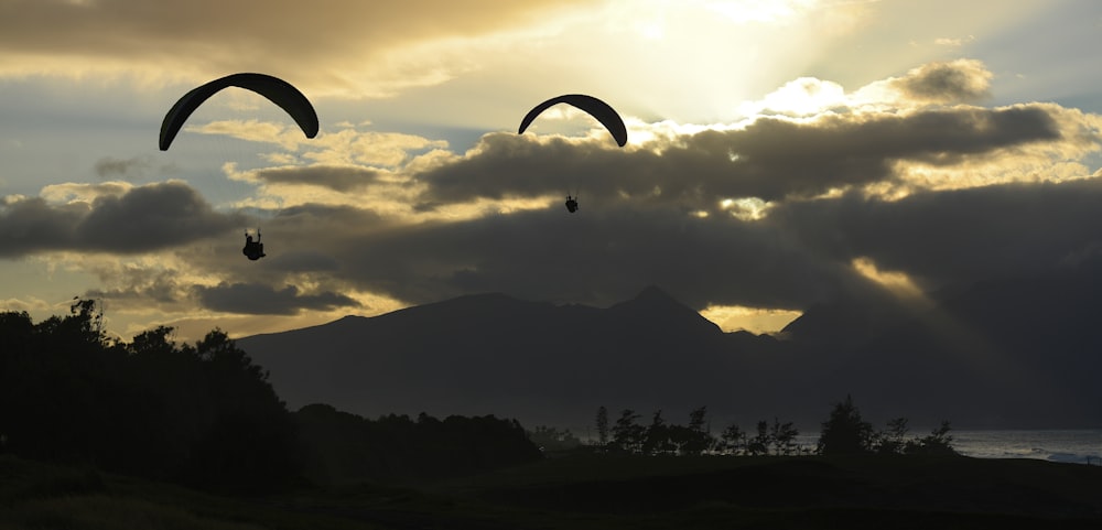 a couple of paraglides are flying in the sky