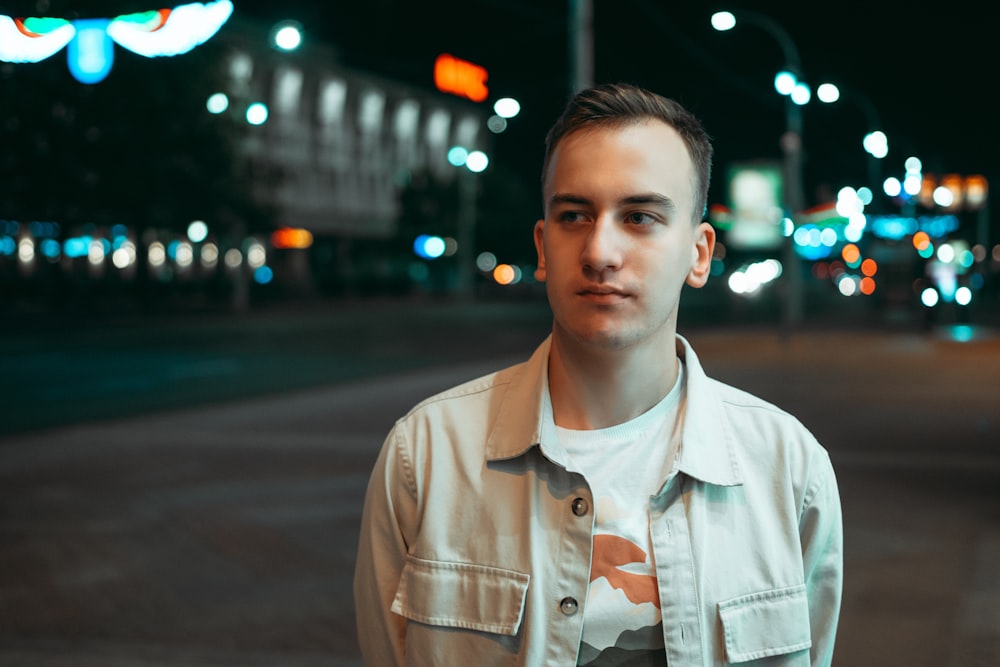 a man standing in the middle of a street at night