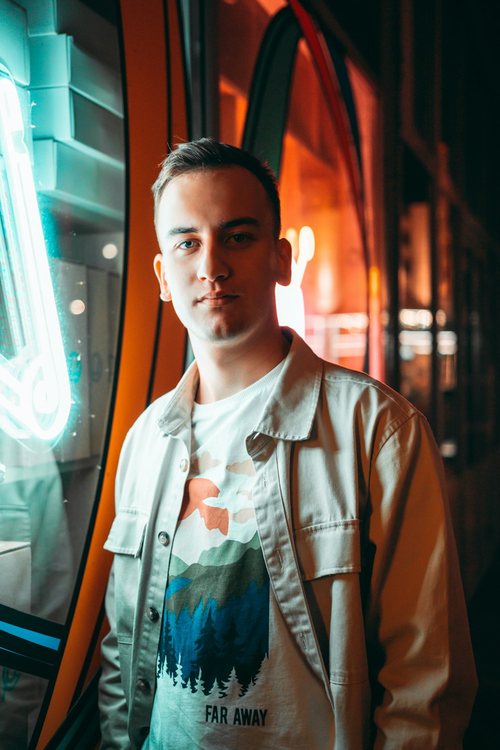 a man standing in front of a neon sign