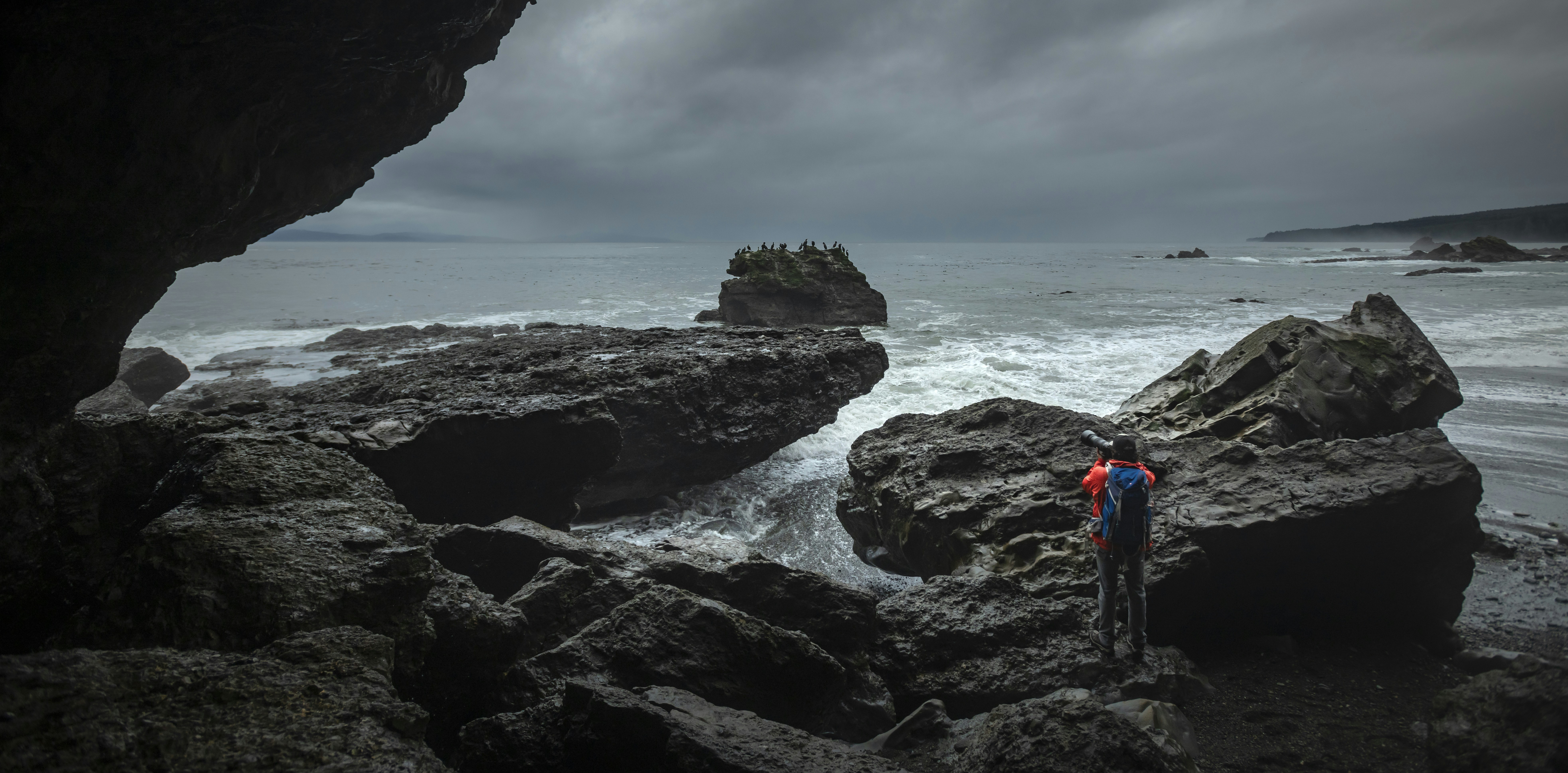 Un couple de personnes debout au sommet d’une plage rocheuse