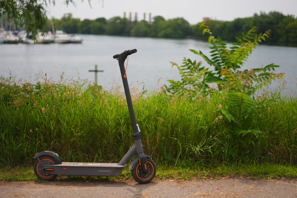 a scooter parked on the side of a road near a body of water
