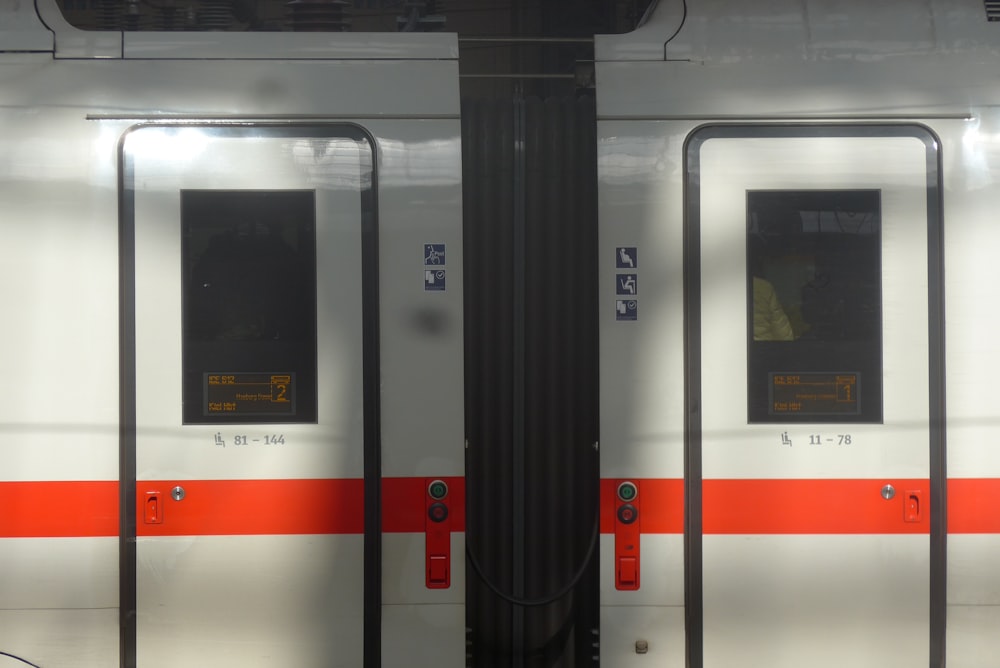 a train with red and white stripes on it's doors