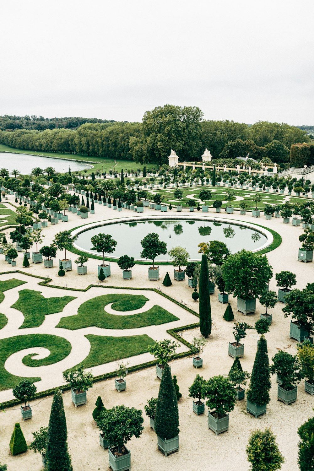 a large garden with a pond surrounded by trees