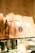 Several brown paper coffee bags are lined up on a glass shelf, each with a label indicating the brand 'Coffee & Water Lab' and specific details about the coffee. The labels feature a graphic of a coffee dripper. The scene is warmly lit, giving a cozy and inviting ambiance.
