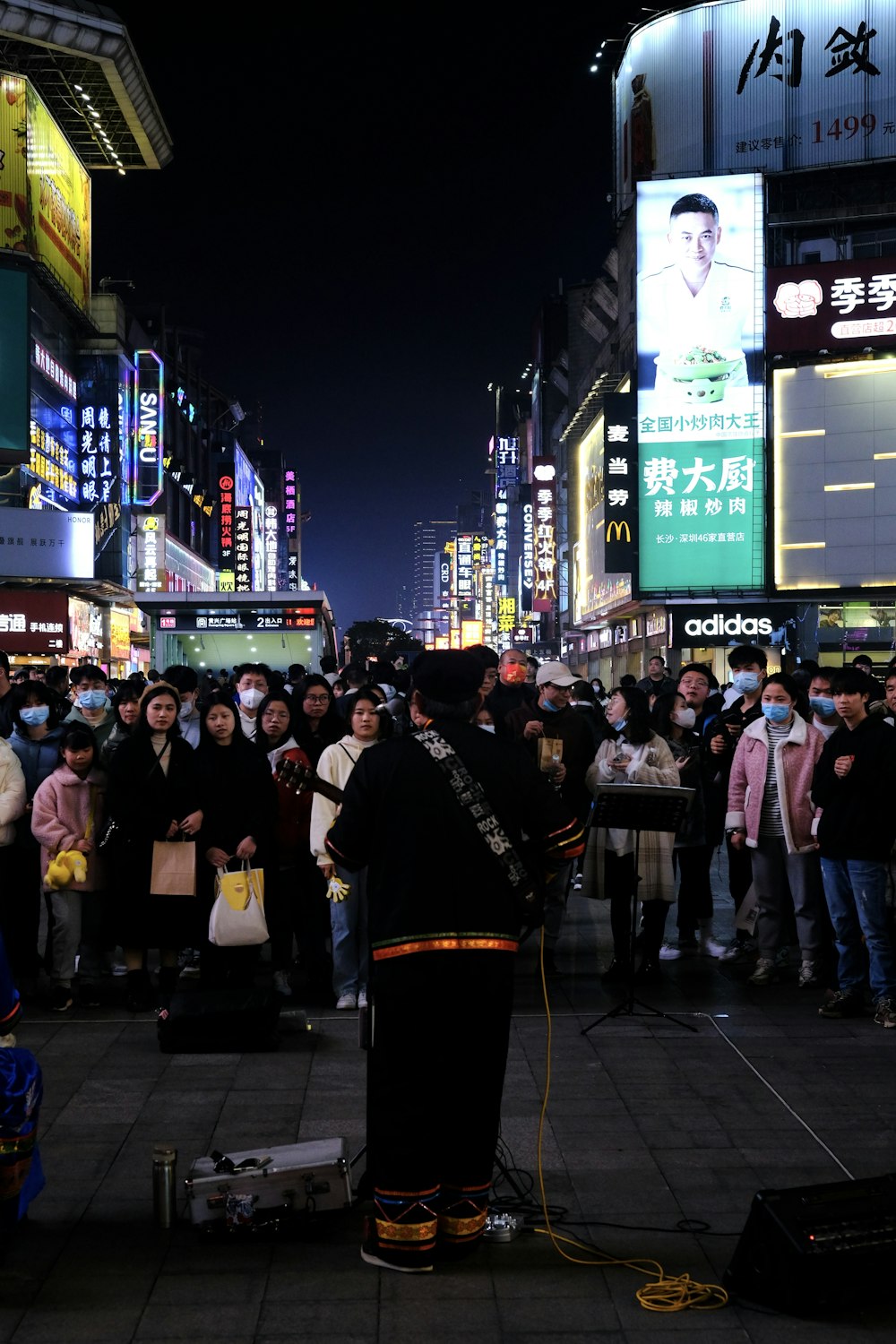 a group of people standing on a street next to tall buildings