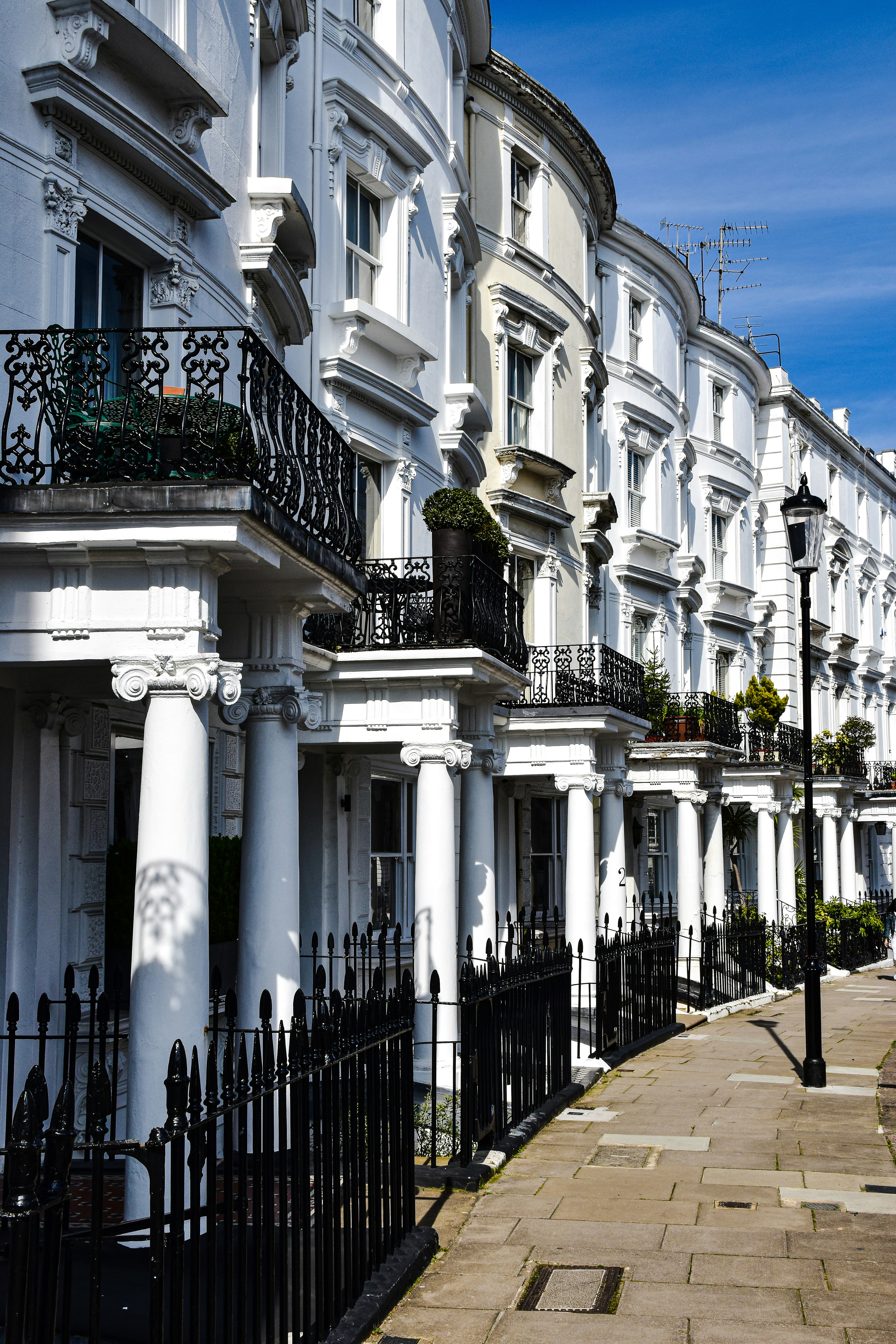 a row of white buildings with black balconies
