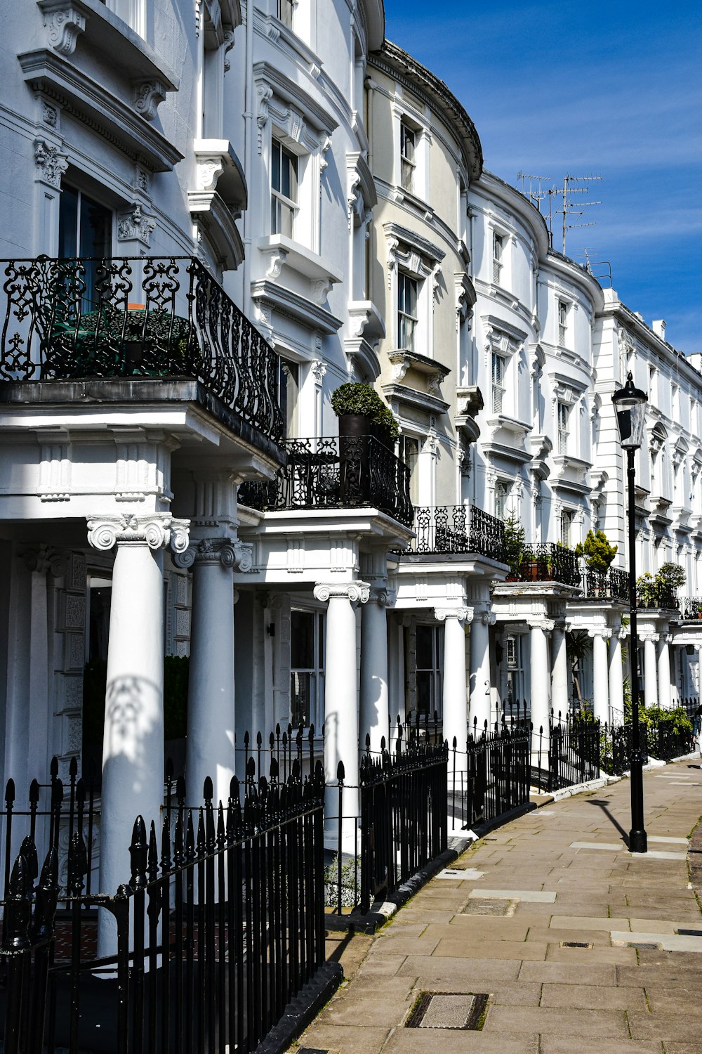 a row of white buildings with black balconies