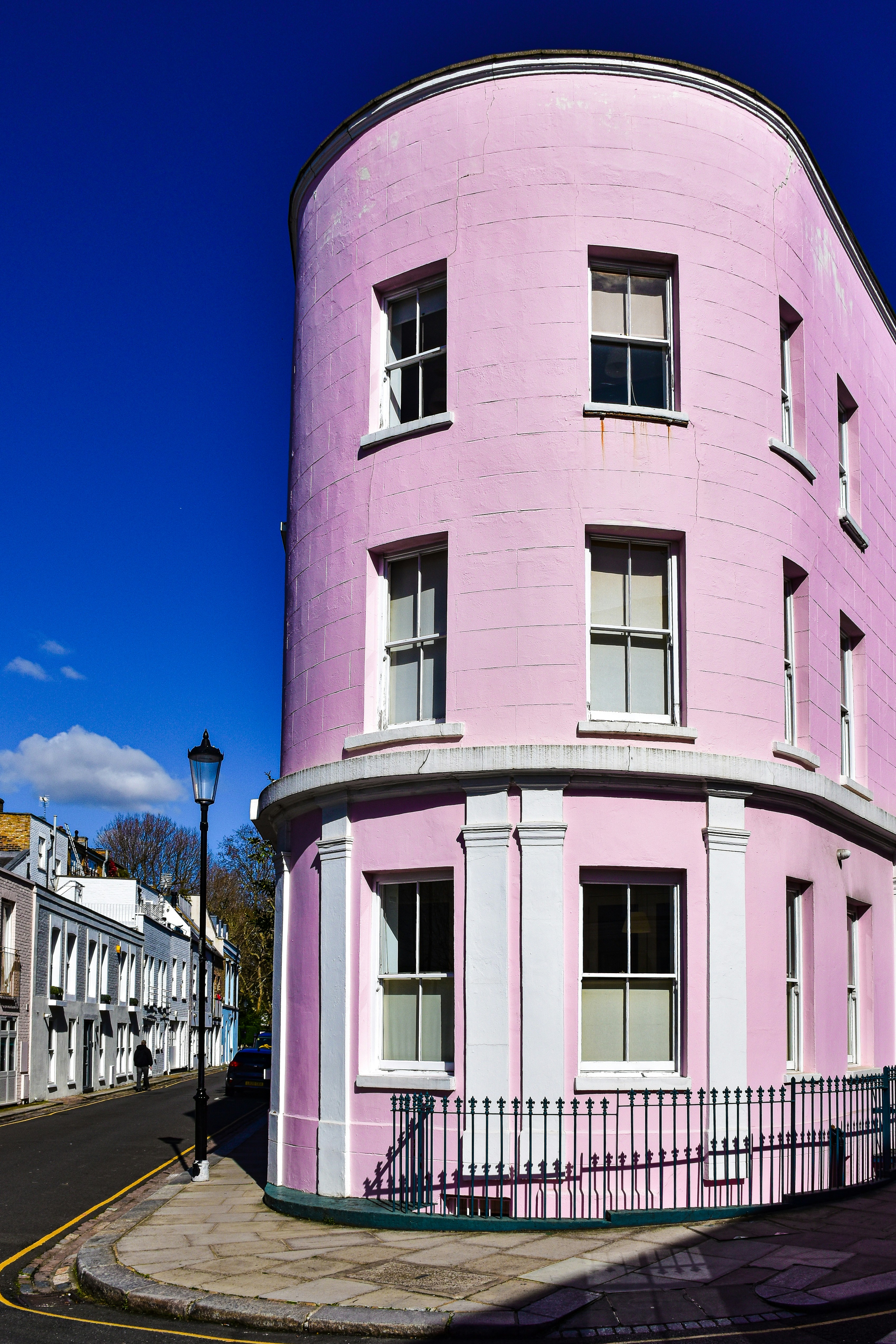a pink building with a black fence around it