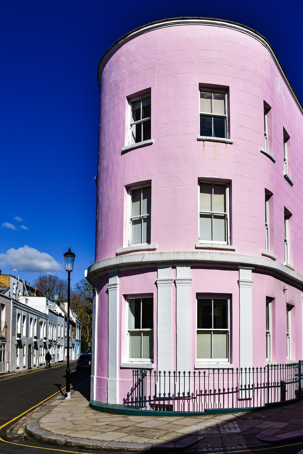 a pink building with a black fence around it