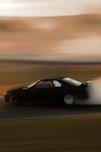 A drifting car kicking up smoke on a race track captured in motion