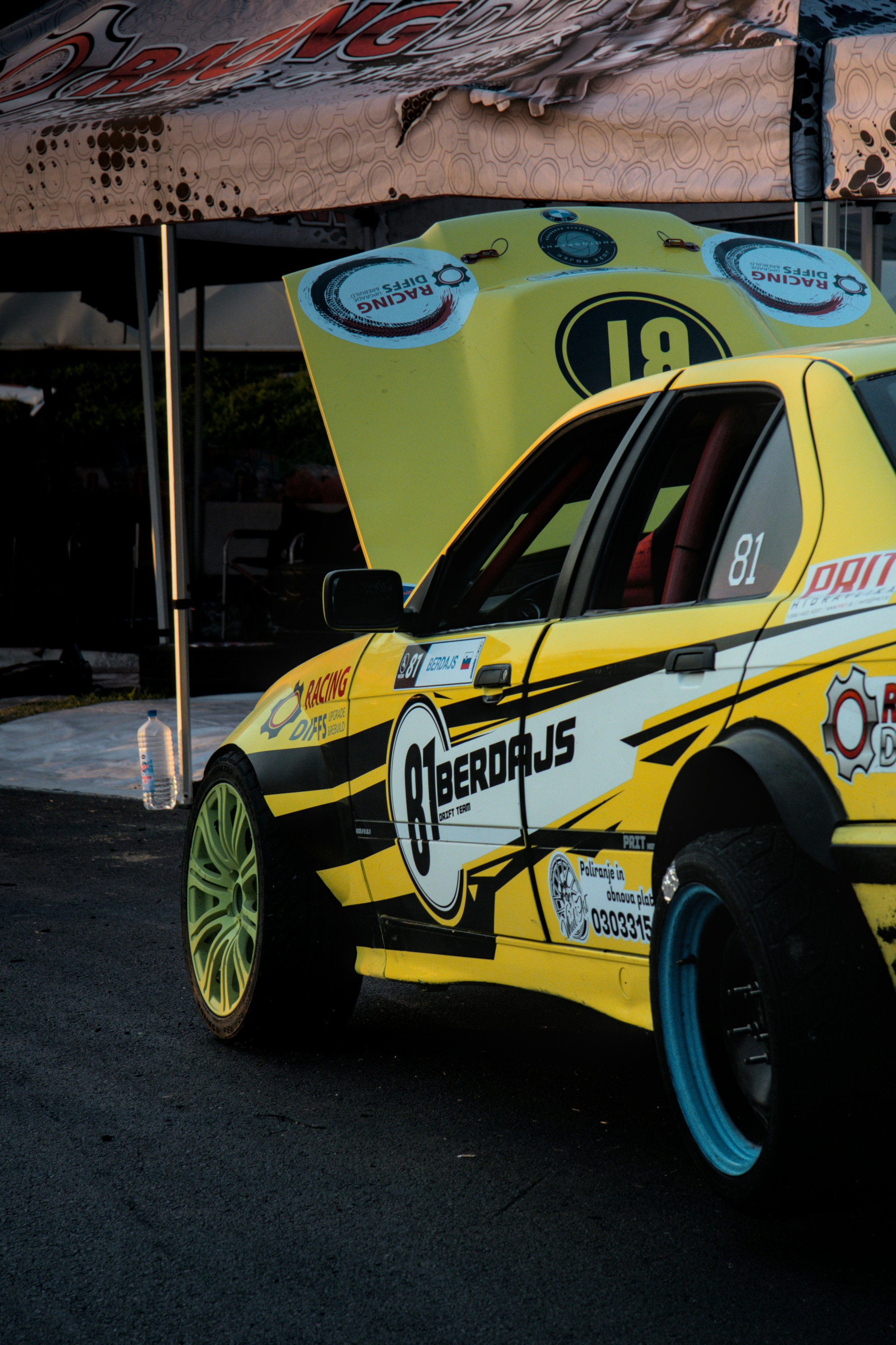 a yellow race car parked on the side of the road