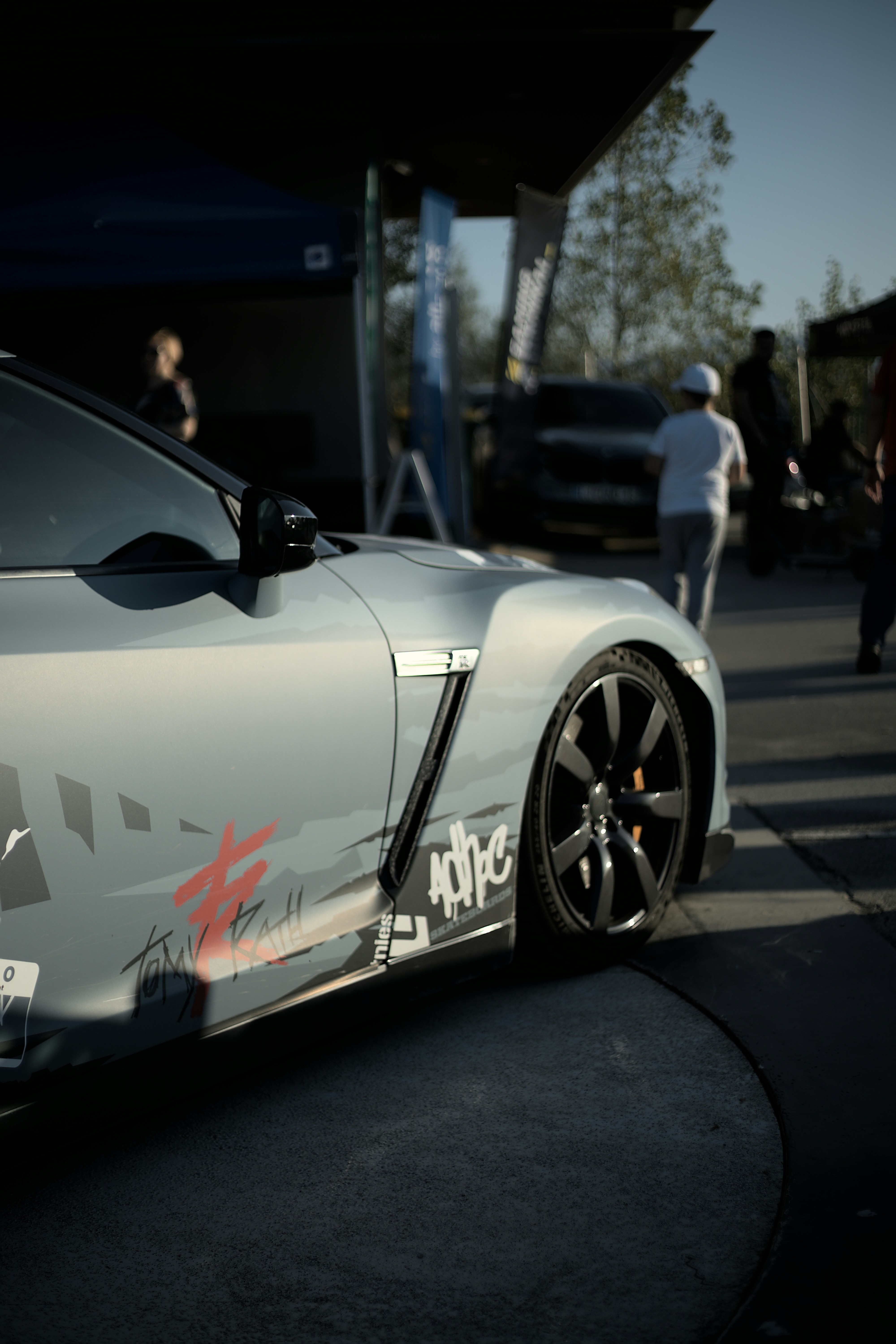 Ein silberner Sportwagen, der am Straßenrand geparkt ist