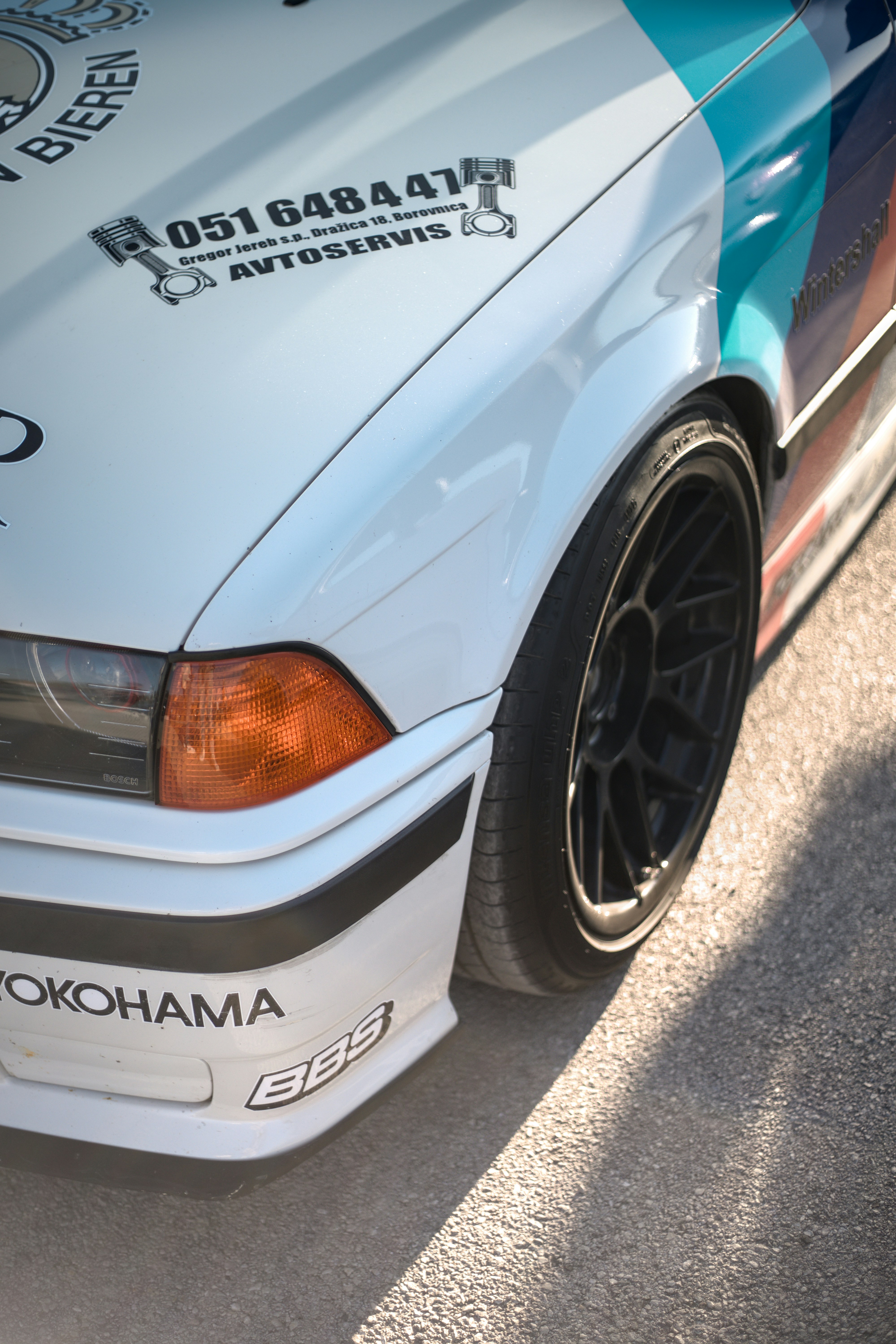 a close up of a white car parked on a street